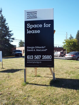 Nepean, Ontario, Canada &ndash; July 27, 2025: An Avison Young "Space for lease" sign stands on a dry grassy lawn in an industrial area on Antares Drive.