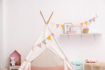 Cute wigwam with garland in stylish child's room, closeup. Space for text © New Africa