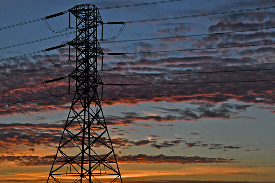 Silhouette of high voltage electrical pylon at sunset 