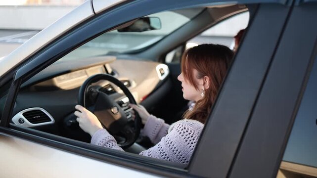 Woman takes driving exam with instructor beside her feeling tense and unsure gripping the wheel tightly while trying to control the car and cope with pressure during difficult test moment