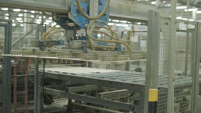A stream of small wooden pieces and offcuts moving along a conveyor belt, representing byproduct management in a large wood factory