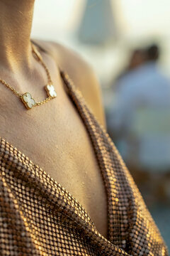 Woman wearing luxury gold necklace during golden hour