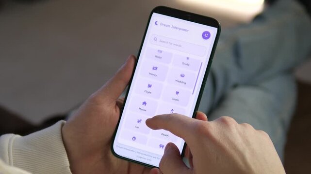 Explore the subconscious with a sleek dream interpreter app. Close-up of hands scrolling through symbolic categories like cat, flight, and money. Perfect for lifestyle tech, psychology, and modern
