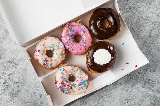 assorted donuts with chocolate frosted pink glazed and sprinkles donuts in box