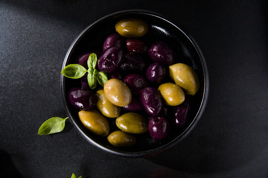 Olives calamata in a bowl on the table. Top view