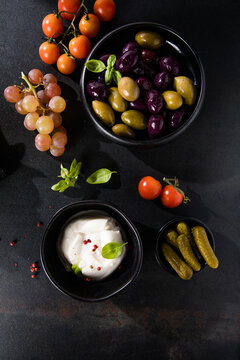 Burrata cheese ball, Mediterranean appetizer antipasti tapas bowls with green and calamata olives feta cheese stuffed pepper herbs