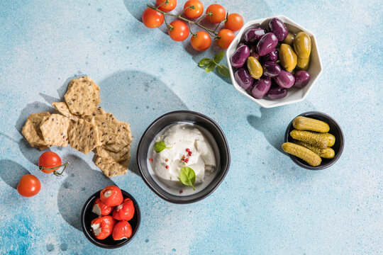 Burrata cheese ball, Mediterranean appetizer antipasti tapas bowls with green and calamata olives feta cheese stuffed pepper herbs