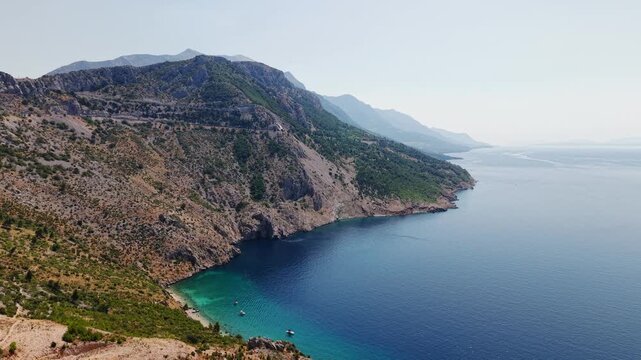 Aerial view of the stunning Vruja beach and Biokovo mountain range on the Makarska Riviera, Croatia, featuring turquoise Adriatic Sea and rugged coastline