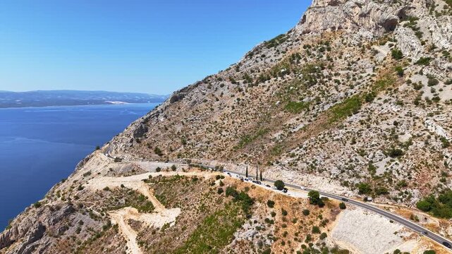 Aerial view of the winding coastal road at Vruja near Brela, Makarska Riviera, Croatia, overlooking the Adriatic Sea on a sunny day