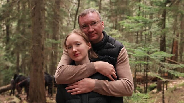 Portrait of daughter and father in a mountain forest.