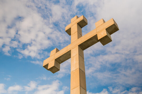 View of huge stone cross monument against white clouds, located on the mountain over Gonio town near Batumi, Georgia. Religion, cloudscape, Christianity, spiritual and Orthodoxy concept