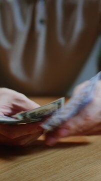Closeup: man hands counting dollar cash banknotes. Caucasian male calculates his income, salary, profit. Making USD currency money, success, wealth concept, make money.