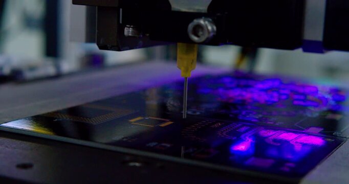 Automated machine precisely installing electronic components on printed circuit board. Close-up shot.