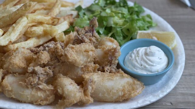 Fried calamari dish represents authentic Mediterranean food experience. Squid widely served in coastal regions and tourism destinations. Seafood plate highlights local cuisine and travel lifestyle.