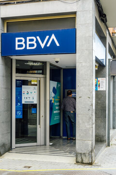 Barcelona, Spain - July 4, 2021. Man operating an ATM at Banco Bilbao Vizcaya Argentaria, BBVA, is a Spanish bank based in Bilbao