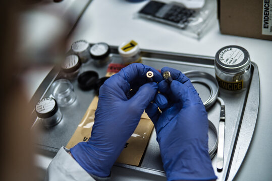 A police ballistics expert is examining two bullets of different calibres linked to a murder