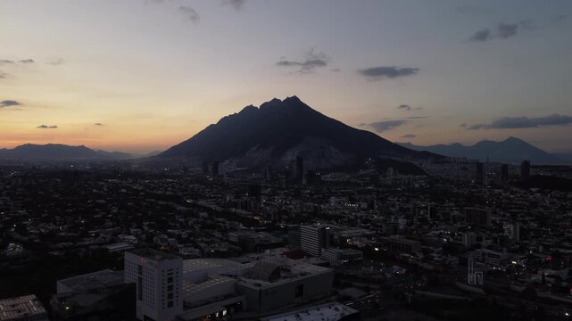Aerial drone view of Cerro de la Silla mountain at sunset with Monterrey city skyline Nuevo Leon Mexico
