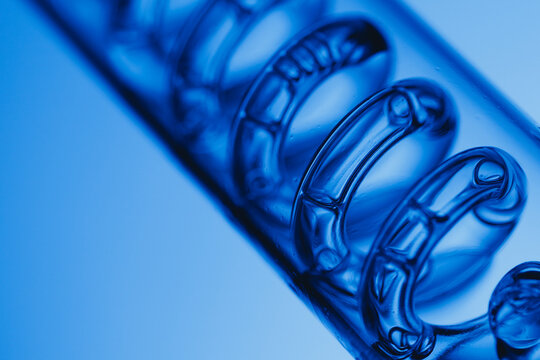 Macro view of Transparent glass spiral in blue with air bubbles for abstract laboratory background