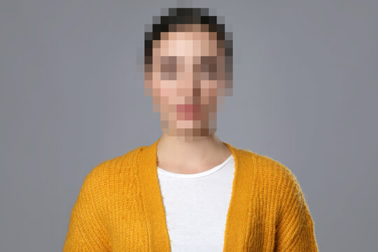 Anonymous woman with pixelated face on grey background