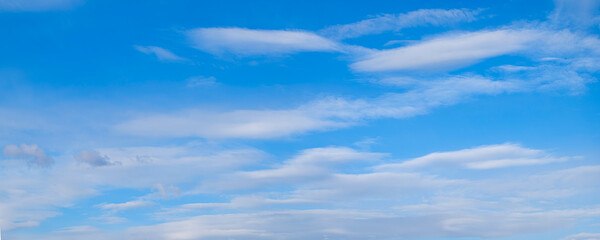 Obraz premium Heaven wide panorama skies blue and clear, with thin, puffy, transparent clouds. sun shines brightly, making sky even brighter. scene is peaceful and serene
