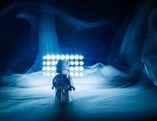 Naklejka premium Toy astronaut standing alone in dramatic smoky light.