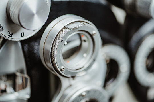 Macro shot of ophthalmic phoropter lens adjustment dial. Detailed macro view of adjustment knobs and numbered scales on a professional phoropter refractor device.