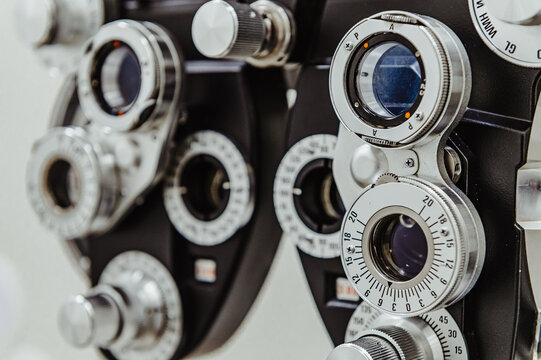 Both banks of ophthalmic phoropter lenses for vision testing. Wide shot of a manual refractor device showing both the left and right lens assemblies in a clinic.