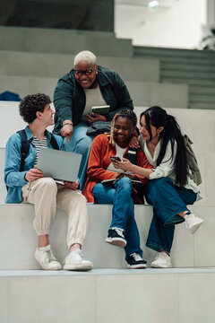 Diverse students collaborating and learning on university campus, using technology for education and group study