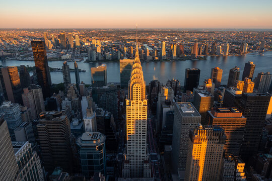 New York City, NY, USA &ndash; October 01, 2025: Elevated view of Midtown Manhattan skyscrapers and Art Deco Chrysler Building at sunset with Queens and Long Island City