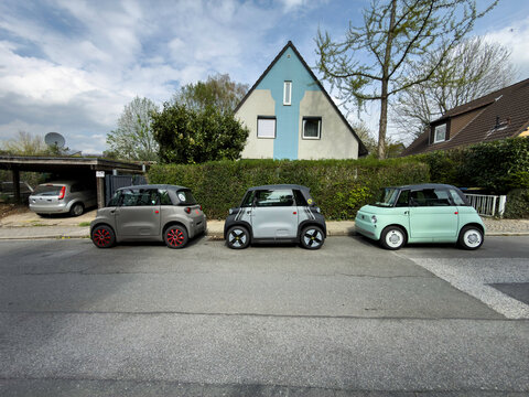 Drei kleine Elektroautos parken hintereinander vor einem Einfamilienhaus in Essen, Deutschland