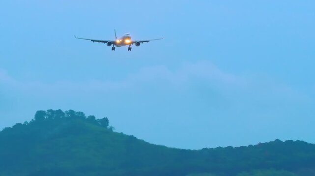 Wide body airplane approaching landing at Phuket Airport after rain. Evening, dusk. Travel concept