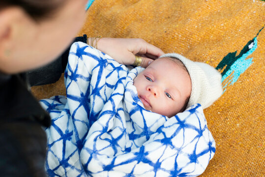 Mom with baby laying on a blanket