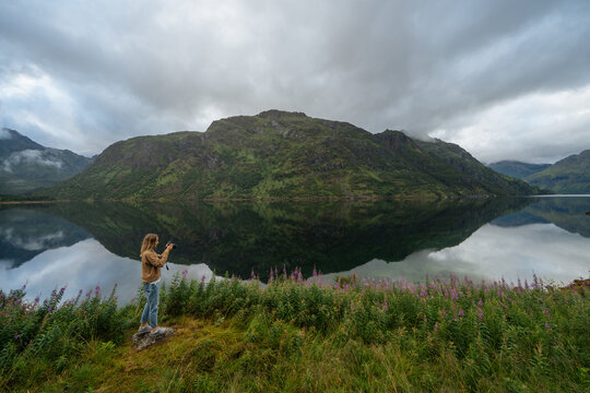 Woman taking picture with camera of lake
