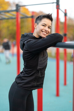 Sportive woman posing at fitness playground outdoors