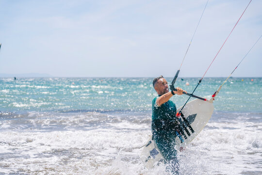 Surfer preparing kite board on ocean beach
