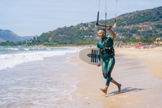 Water sports enthusiast preparing kite surfing equipment