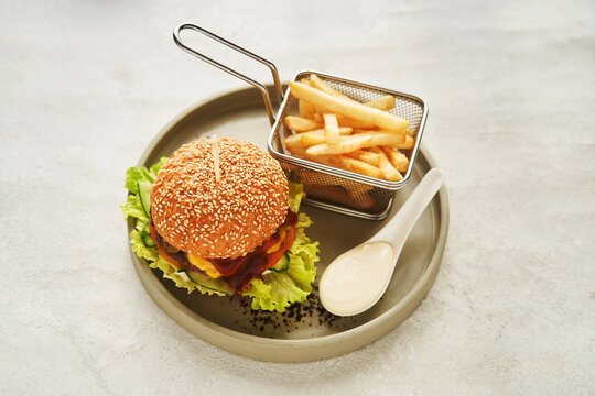 Neat burger with French fries, served in restaurant