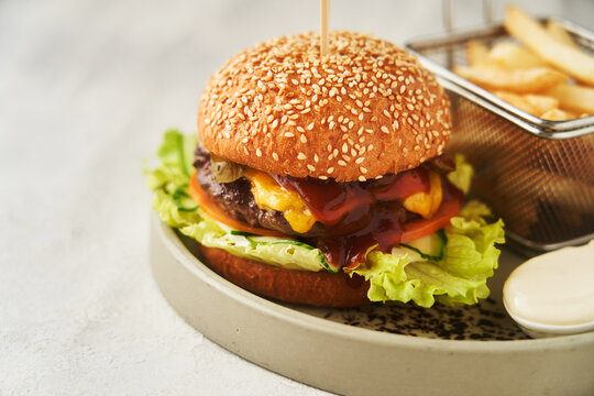 Neat burger with French fries, served in restaurant