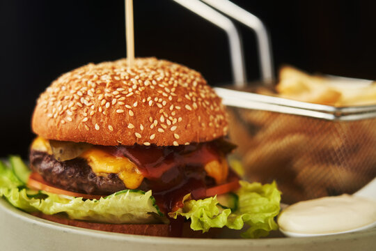 Neat burger with French fries, served in restaurant