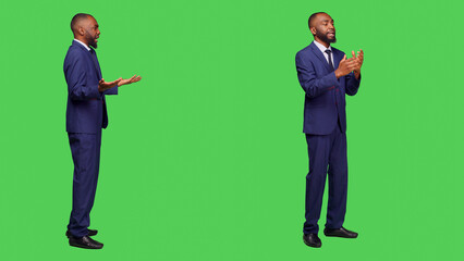 African american worker fighting and having argument on camera, feeling displeased and furious over full body green screen. Young businessman in suit in conflict being angry and aggressive. © DC Studio