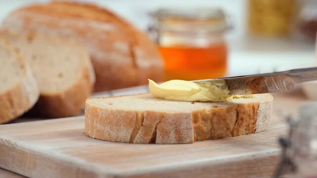 Butter spreading on fresh bread slice, close up homemade breakfast scene, copy space
