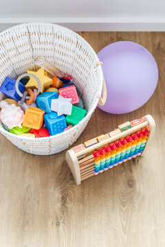 white basket with silicone baby toys abacus and balloon early learning concept