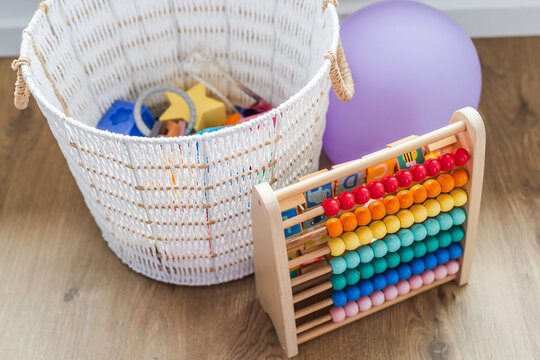white basket with silicone baby toys abacus and balloon early learning concept