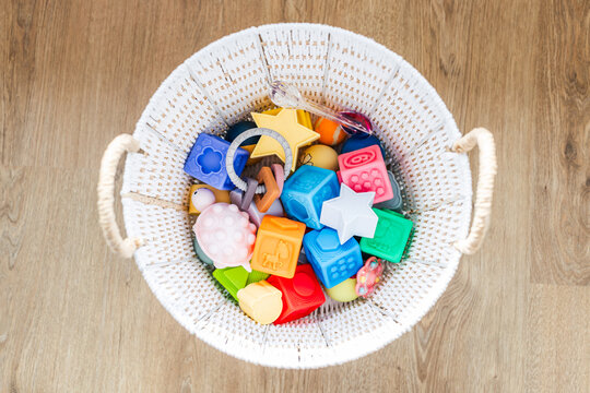 white basket with silicone baby toys abacus and balloon early learning concept