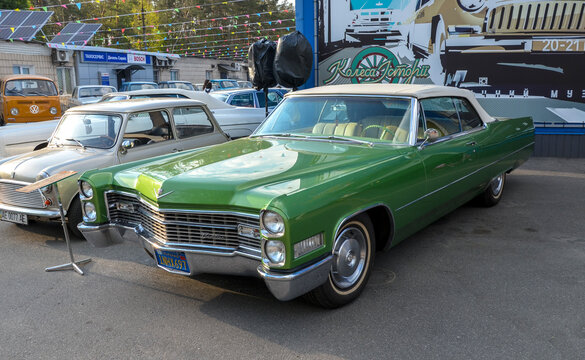 Stunning green Cadillac DeVille convertible, classic American land yacht, with its sharp fins and chrome grille, epitomizes mid century luxury and style