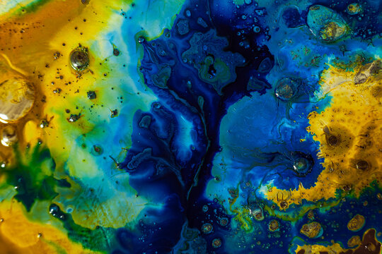 Colorful abstract design with blue, yellow, and green patterns in fluid art
