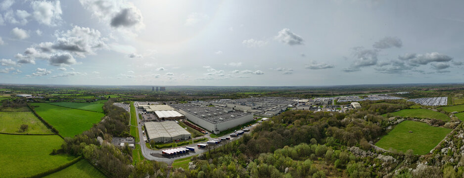 Aerial view of the Toyota manufacturing plant and surrounding industrial buildings with green fields and cooling towers in Derby, England, United Kingdom.