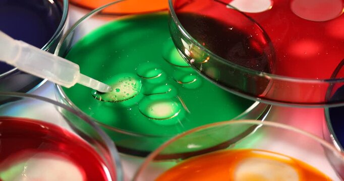 Scientist stirring sample in Petri dish at white table, closeup