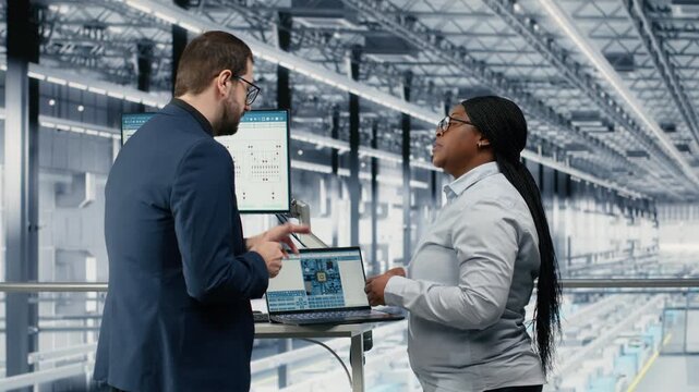 Woman and microchip factory colleague using AI to develop innovative technology roadmap. Coworkers use artificial intelligence to develop high tech semiconductor foundry process engineering, camera B
