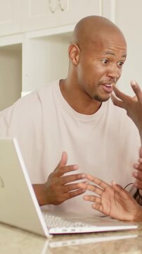 Vertical video: Teaching dad guiding son joining to learn on laptop at kitchen counter striped tee